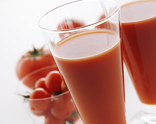 photo of clear drinking glass filled with tomato juice